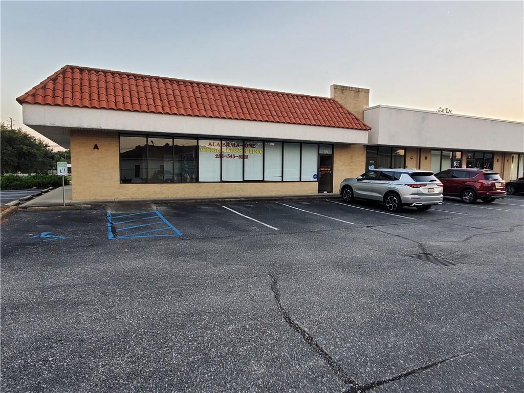 View of commercial property featuring uncovered parking