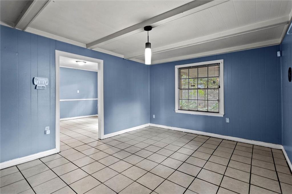 Tiled empty room with wooden walls and beamed ceiling