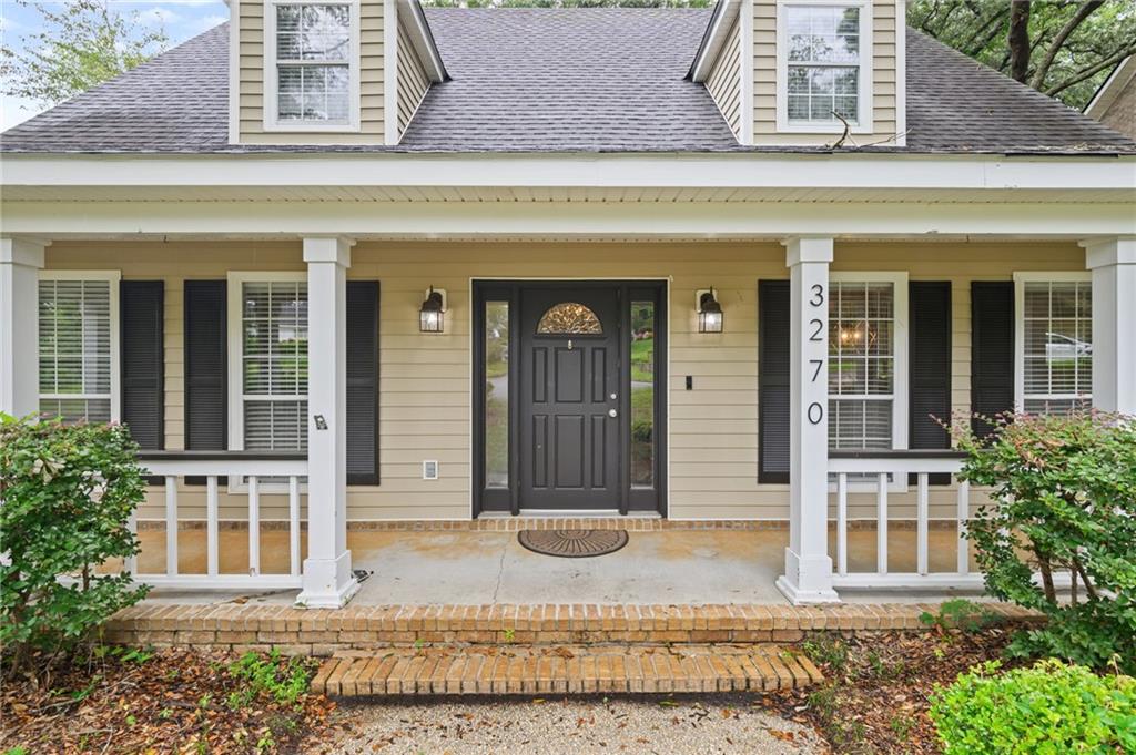 Inviting front porch entrance with a dark paneled door featuring an arched transom window