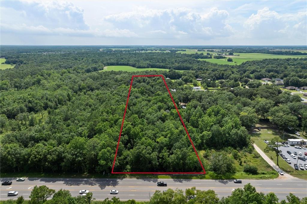 Aerial view of property's location featuring a heavily wooded area and property parcel outlined