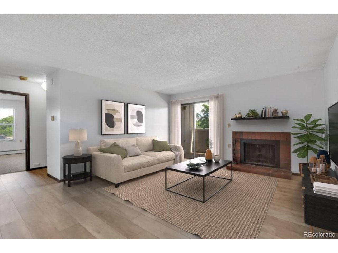 Living room with fireplace and sliding door to deck. *Virtually Staged*