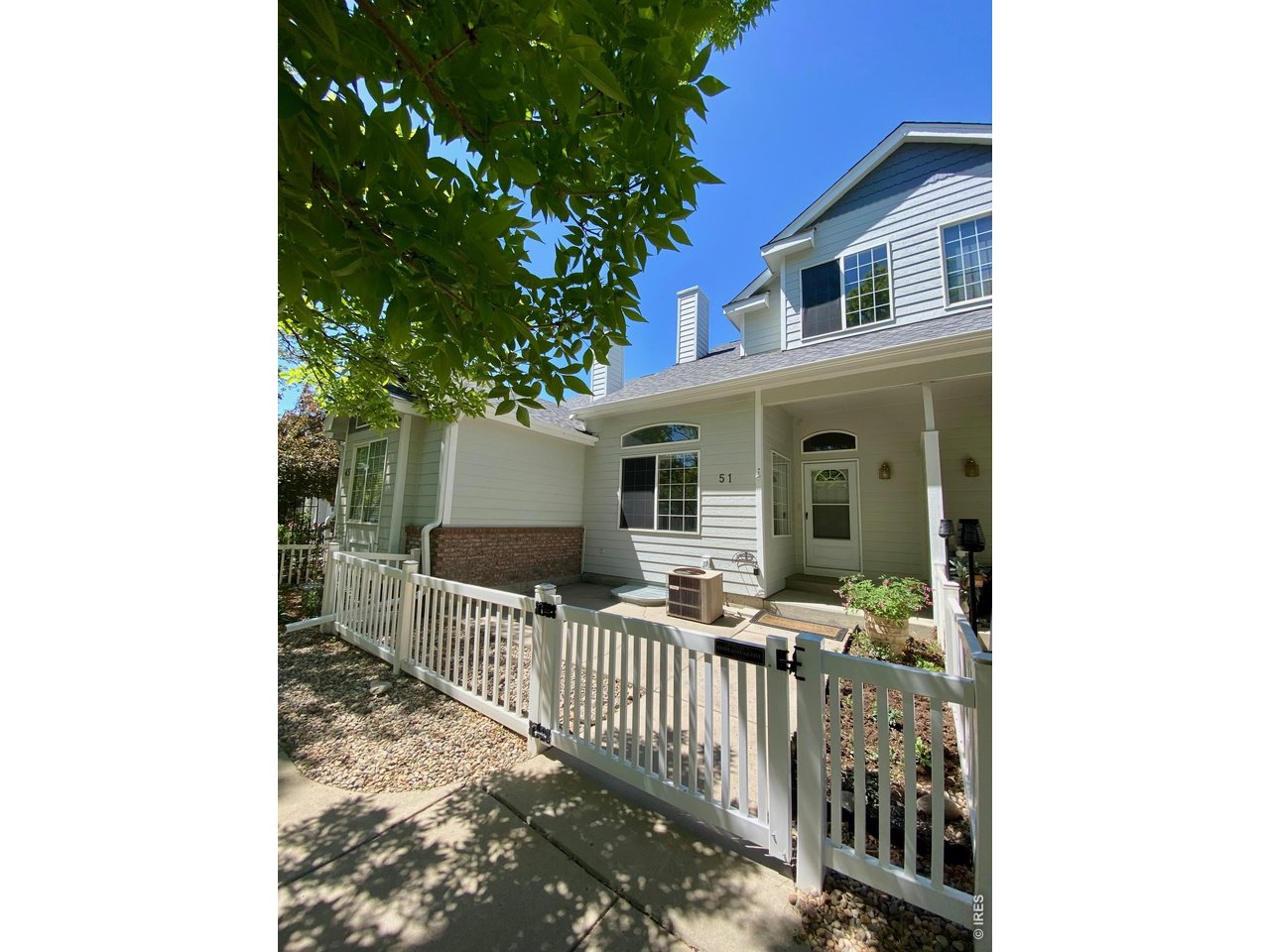Welcome home! Private, gated front patio with a charming garden gate and soft shade, creates an inviting entry.