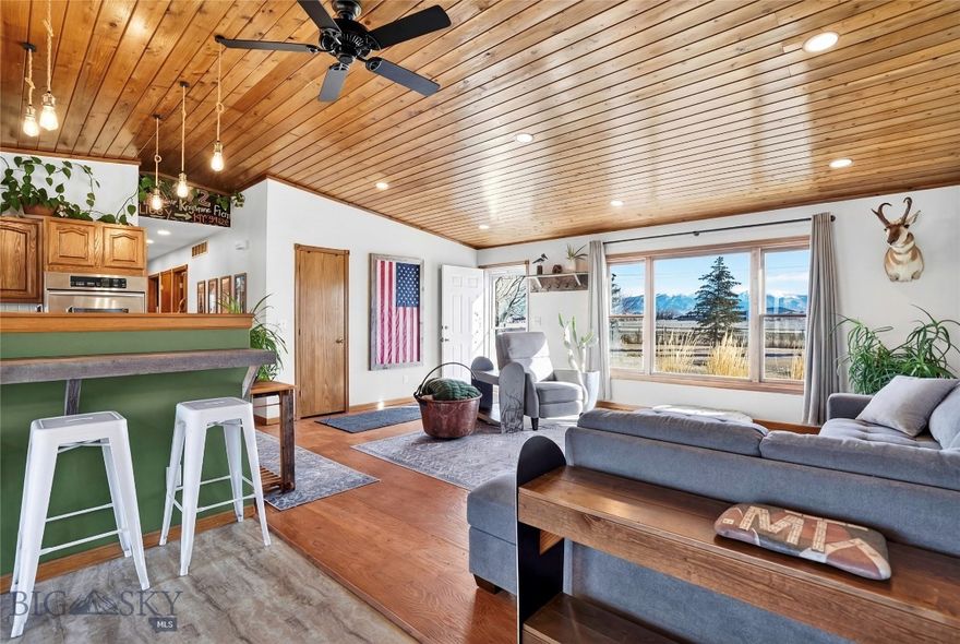 Set against wide open Montana skies just minutes from the charming town of Manhattan, this beautifully updated property offers space, privacy, and a lifestyle connected to Montana’s outdoors. Situated on 1.18± acres with no HOA, the property provides lasting openness and peaceful rural living while remaining conveniently close to town amenities. Inside, the home welcomes you with warm natural light and an inviting open layout connecting the living room, dining area, and kitchen, ideal for everyday living and gathering. The living room’s front window perfectly frames stunning views of the Bridger Mountains. The kitchen features abundant cabinetry and counter space, double wall ovens, and a spacious walk in pantry, along with recent upgrades including a new sink, fixtures, disposal, and dishwasher. Updated lighting with energy efficient LED fixtures and fresh interior paint create a warm and functional living environment. The primary suite offers an updated en-suite bathroom and added storage. Two additional bedrooms provide flexibility for guests, office space, or hobbies, including a kids bedroom featuring a custom built in bunk bed with storage underneath. A generous laundry area adds everyday convenience. Outdoor living shines with a rear deck ideal for quiet mornings and evenings around the outdoor firepit, while the expansive front porch captures incredible Bridger Mountain views. The property also features a 30x32 heated and insulated shop, a powered and insulated mini barn, a functional shed with root cellar full of shelving, and a fenced garden area or space for animals. Friendly goats currently call the backyard home, adding to the property’s rural character. The land has been organically maintained and thoughtfully improved over time with no chemicals used. Located just minutes from multiple Gallatin River access points for fishing, floating, and recreation, as well as nearby trails, parks, schools, and Bozeman Yellowstone International Airport, this property offers an exceptional balance of convenience and tranquility. Whether enjoying evenings around the fire or taking in Bridger Mountain views from the porch, this home delivers an authentic Montana lifestyle defined by space, comfort, and connection to the outdoors.