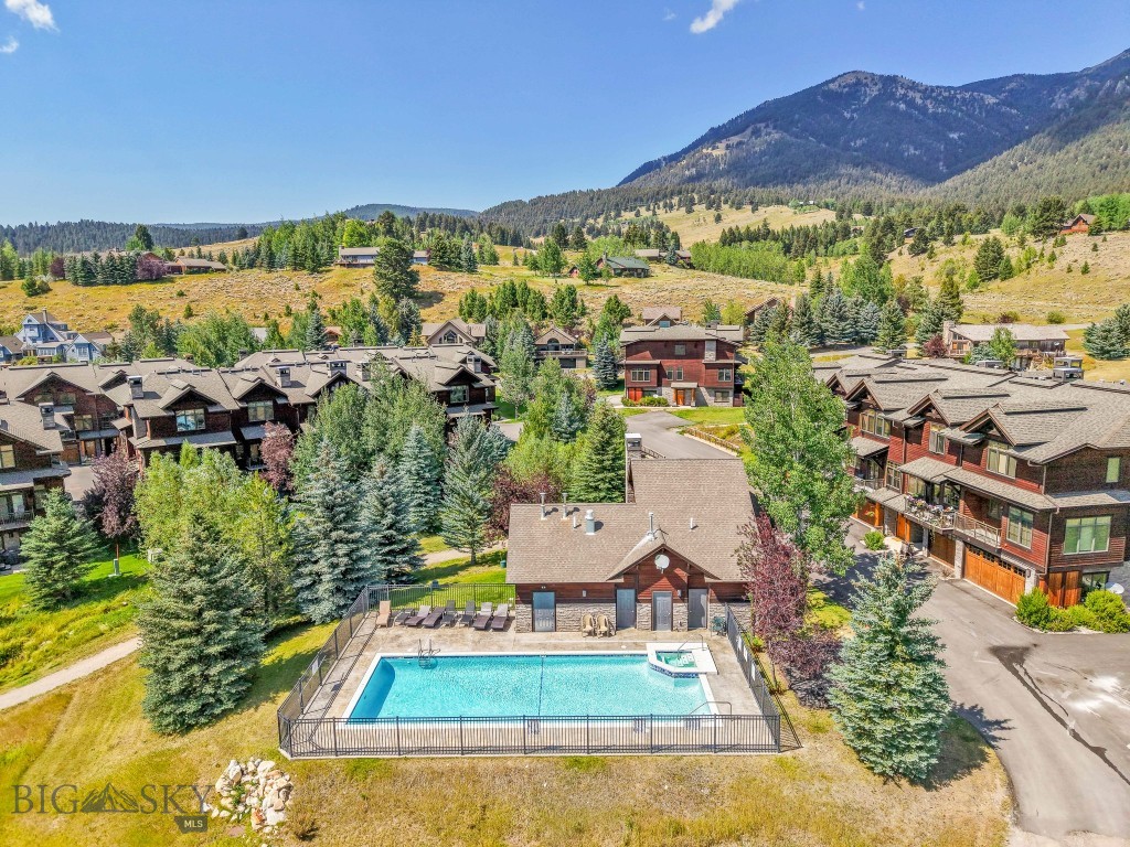 Immaculate Meadow Condo in the Heart of Big Sky - 
Set in a serene meadow setting, this beautifully maintained condo offers direct access to a scenic nature trail that leads to a community park and pond. From your doorstep, explore a network of hiking, biking, walking, and cross-country ski trails that connect to the National Forest and Big Sky Resort Golf Course.
Enjoy panoramic views of Yellow and Dudley Mountains from the living room, upper deck, and lower patio. The main level features an open-concept design with circular-sawn hardwood floors, tall ceilings, and large windows that flood the space with natural light. A chef’s kitchen with high-end finishes flows effortlessly into the living area, which includes a cozy fireplace and built-in desk nook.
Upstairs, the spacious primary suite includes a walk-in closet and a well-appointed en-suite bathroom with a tiled glass shower and soaking tub. A generous guest bedroom with its own walk-in closet and full bath completes the upper level.
The lower level offers an attached single-car garage, a full bathroom, and a third bedroom—currently used as a second living space—with walk-out access to a private patio pre-wired for a hot tub.
Relax to the peaceful sounds of the nearby pond and waterfall from the back patio and deck, while taking in the mountain views and frequent wildlife sightings, including moose.
Residents enjoy access to a well-appointed community clubhouse, featuring an exercise room, pool, hot tub, fireside lounge, kitchen, and game area—perfect for entertaining or unwinding after a day of adventure.
A brand-new cold roof has just been installed and has been paid in full, by the seller. Lovingly maintained by the original owners, this residence is in like-new condition.
Whether you're seeking a full-time residence, a vacation getaway, or an investment property, this immaculate condo checks all the boxes. Ask your favorite real estate agent for a tour today!
