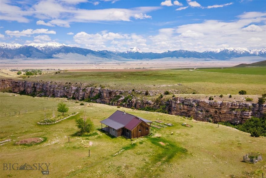Tucked along the rim of WigWam Creek Canyon with forever views stretching across conserved ranchland and surrounding mountain ranges, this Montana property captures the kind of setting that’s becoming harder to find. Located on 5± acres in Shining Mountains II, the 1 bed, 1 bath log home with loft offers approximately 1,560± sq ft of rustic character and wide-open space just 15 minutes from Ennis.

Vaulted wood ceilings, large windows, and warm log accents bring the outdoors in, while the loft provides additional sleeping or flex space. The spacious bathroom features a large soaking tub perfectly positioned to take in the mountain views. Step outside to enjoy the dramatic canyon setting, abundant wildlife, and unobstructed southern views over the Bar 7 Ranch, protected by conservation easement.

Set up for enjoying the Montana lifestyle, the property includes horse corrals, loafing sheds, garden beds, and room to expand. HOA access includes trout-stocked Haypress Lakes, National Forest Service access, and miles of nearby trails ideal for horseback riding, hiking, ATVs, and exploring.

Conveniently located near the Varney access on the Madison River and less than an hour from Yellowstone National Park, this property offers privacy, recreation, views, and authentic Montana living.