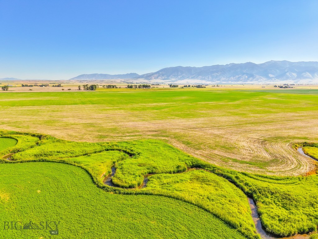 Discover this picturesque legacy farm located just outside of Bozeman with some of the oldest water rights from Ross Creek. Spanning 313 acres, this sub-irrigated farm offers alfalfa and naked oaks in addition to other crops which ensure income opportunities while maintaining exceptional privacy and breathtaking views of the Gallatin Valley. The conservation easement in place protects the land from development with the exception of an 8-acre build site, ensuring its agricultural and environmental value is preserved for future generations. Adding to its appeal, the South Fork Ross Creek meanders through the property, providing an excellent water source for irrigation and enhancing the scenic beauty of the farm. The 8-acre designated build site on the far north end of the property provides incredible privacy and unobstructed views.