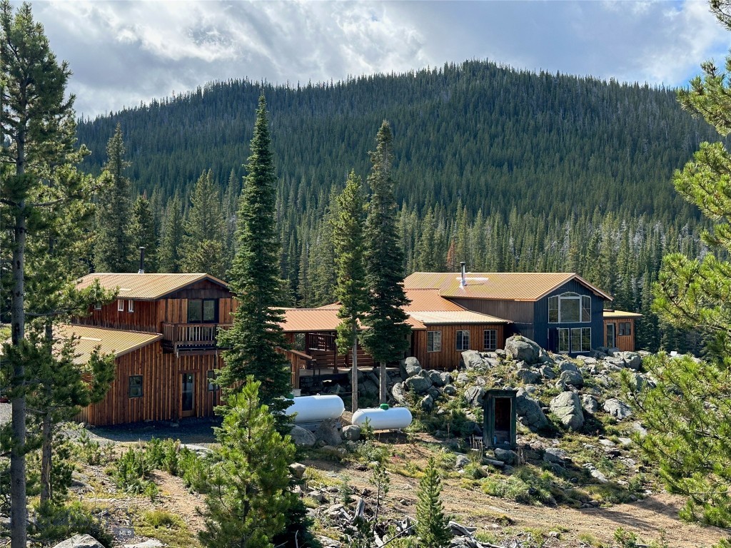 Off-Grid Hunter's Paradise! This amazing, off-grid, seasonal home was built over the last two decades by a very handy woodsman who owned the land for quite some time. Much love was invested into this 31.02-acre property and the 4480 sf home on it. The log work, lighting and decor show character and attention to detail. Last year the property was purchased by a motivated builder who has done an impressive facelift, tightening up the construction, protecting it from the long winters, while beautifying it inside and out. The master bathroom is now complete; a new metal roof was installed with new plywood decking and ice and water shield; insulation was increased; exterior was sealed; siding was repaired; concrete was poured in the basement, garage, and around the foundation; top-of-the-line solar was installed; a new generator was added; 1500 gallons of propane tanks were added; the property has been cleaned of possessions; driveway has been improved with truckloads of gravel; an electrical contractor updated the wiring; a licensed plumber updated the plumbing; tankless propane water heater is working. Now it's time for you to enjoy the fruits of his labors. The views from the picture window are breathtaking. A stream runs through the property year round. Elk, deer, bear, moose and other wildlife roam the property. Forest service access is all around and the roads will take you in all directions, ripe for exploration. The hunting is phenomenal. This property has seasonal access at 7400 feet elevation, 6.4 miles past county plowing and 3.75 miles past local resident plowing. No well in place. Home water is provided from the stream in the warmer months through a cistern and gravity feed. Drinking water is brought in.