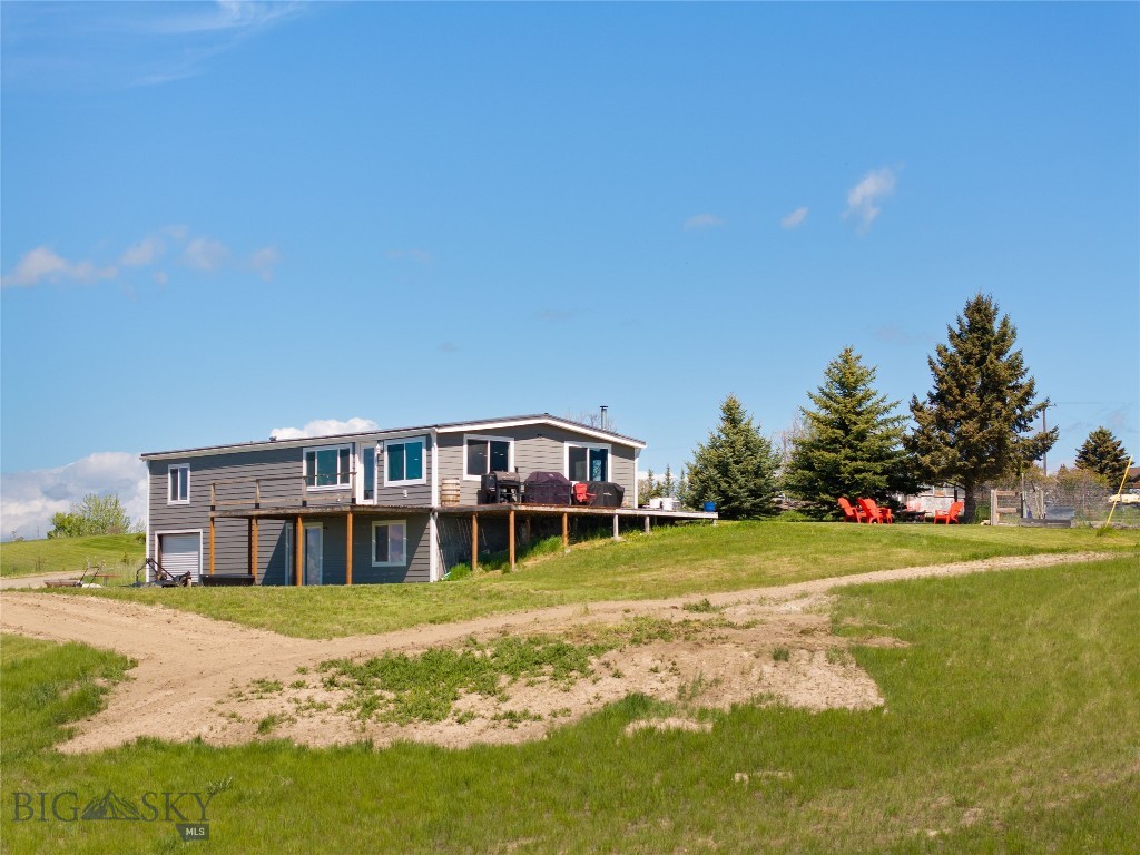 Perched on a high bench just north of Belgrade, this 9.38-acre property offers some of the most spectacular views in the valley. Enjoy panoramic, unobstructed vistas to the east, south, and west—truly a rare find. While the 1,404 sq ft manufactured home on an equally sized unfinished basement offers 3 bedrooms, 3 bathrooms, a garage, and plenty of space to spread out, the true value lies in the land and setting. Whether you're dreaming of a hobby farm, horse property, or simply a private retreat with unmatched views, this acreage has endless potential. Additional features include a hot tub for soaking under Montana skies, a greenhouse for year-round gardening, and a 2022 Kioti CK2610 tractor with loader, tiller, angle blade, and mower to help you work the land with ease. Bring your animals, your vision, and your appreciation for wide open space—this is Montana living at its best.