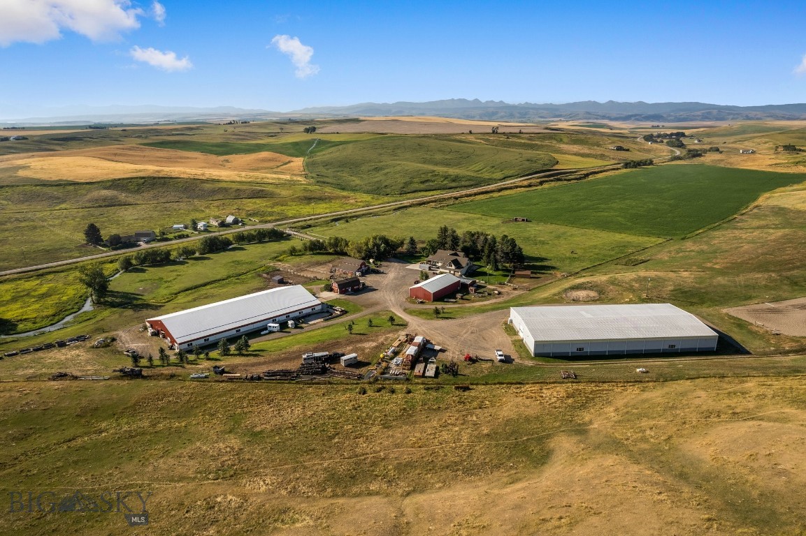This property is a dream for horse enthusiasts and the perfect small ranch operation. If you've been looking for a property that has it all, this is it!! Settled amongst Camp Creek, cottonwoods, lush farm land and stunning views, this premier equestrian estate on 96± deeded acres in Gallatin Valley is just 15 minutes from Manhattan & Belgrade, or 25 minutes from Bozeman. This unique offering features a 4900+/- SF home (prepped for remodel), extensive horse facilities, productive irrigated ground, and Camp Creek meandering through the property. The ranch includes 40± acres of wheel-line irrigated fields, 49± acres of native pasture, and 10± acres of improvements. Amenities include an expansive indoor riding arena, indoor/outdoor boarding facility, tack room, outdoor arena, ample hay storage, two historic barns, machine & equipment shops, a gym and "trophy" space, and well-designed paddocks. The ranch previously supported a boarding operation and yields about 200 tons of grass/alfalfa hay annually. The main home, originally a historic farmhouse, was renovated in 2011 with a large addition. The home is currently in a “ready to remodel” condition. Bring your vision to make it your own! 40 Shares of Low Line Canal are included for irrigation. With rural views of the Spanish Peaks and Bridger Mountains, mature trees, creekside and an irrigated backyard oasis, this productive ranch offers the perfect blend of function, beauty, and potential in one of Montana’s most desirable locations. Some interior images are AI images to assist with "remodel vision." Home and property is to be sold as-is.