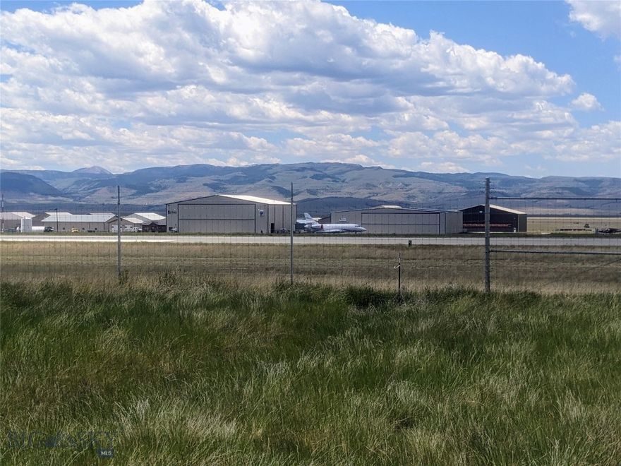 5.961-acres located on the east side of the Ennis - Big Sky Airport (FAA LID: EKS) with direct taxiway access onto the 7400' runway. The airport is located 6 miles south of Ennis MT and 30 miles to Big Sky via the private Jack Creek Road. The airport is part of the National Plan of Integrated Airport Systems and categorized as a general aviation airport. The Covenants for Shining Mountains Airpark categorize Lot 20-B2 as "Airport Commercial" which permit a hanger and / or residential or commercial use. The property offers outstanding views of the surrounding mountains and non-public access to the Lee Metcalf Wilderness area and National Forest Lands. The area is home to world class fishing, hunting, hiking, and winter recreation. Power and fiberoptic communications are to the lot. An unimproved grass / gravel taxiway is in place perfect for a tail dragger. Runway access is possible through the fence if the new owner chooses to install a gate and necessary turf or asphalt taxiway improvements per county and FAA regulations.   The current airport through the gate access agreement restricts aviation activities to non-commercial aviation use.