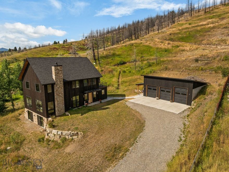 Beautiful custom home on 5 acres in coveted Bridger Canyon. Less than 10 minutes to downtown Bozeman for shopping, restaurants, community events and nightlife. Head north to Bridger Bowl Ski Area and the growing summer and winter trails of Crosscut Mountain Sports Center. 44 Midway Bridger Road is a modern 3 bedroom 3.5 bath home in the heart of Bridger Canyon with everything on your list. The exterior features a Japanese style Shou Sugi Ban charred wood finish that is accented by a full stone chimney, stone landscape features and large windows. Enter the main floor through the family access with built in storage, sitting bench, coat racks, and room for shoes. Formal guests can come in the main entry with the large 8ft oak door and access to the dining/ living area. Throughout the home you will notice oak cabinets, doors, flooring and handrails as well as unique light fixtures, countertops and tile. Walk through the dining room to the large family room with 3 walls of windows, a reading area and a floating wood burning stove with built in fan. The kitchen features stainless appliances, oak veneer cabinetry, large farm-style sink, island, and access to a covered deck with propane hookups for grilling. Off the back of the home is a thoughtful main floor master suite with access to the back yard, full bath with tiled floor and walls, floating cabinets, a large soaking tub, and walk-in closet. Upstairs you will find an additional living area great for cozy nights or watching your favorite show, along with 2 matching bedrooms with walk in closets, a full bath, office, loft and a large balcony overlooking the back half of the property. Downstairs you will appreciate the walkout basement with flex space for guests, home gym, art studio, music room, additional living space, storage, laundry and a 3/4 bath with tile shower. The detached 3 car 30ft x 40ft garage matches the exterior character of the home and is oversized for larger vehicles and storage. Beyond the garage is a terraced additional yard space with room for a fire pit or additional gathering space. Hiking up the 5 acre property from there will get you expansive views of the valley below!