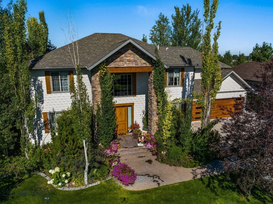 Welcome to this stunning custom home in the highly sought-after Wylie Creek neighborhood. Thoughtfully designed and beautifully maintained, this four-bedroom, four-bathroom residence is set on a lush, professionally landscaped corner lot surrounded by mature trees, offering privacy, serenity, and true Montana living just minutes from downtown Bozeman.
As you enter, you’re welcomed by a dramatic two-story foyer that opens into a sunlit living room with soaring ceilings and a striking floor-to-ceiling rock fireplace. This inviting space sets the tone for the rest of the home, where natural light and warm finishes create an atmosphere of comfort and elegance.
The chef-inspired kitchen features custom cabinetry, a generous island with storage, high-end stainless steel appliances, and a dedicated wine fridge. The open-concept design allows effortless flow from the kitchen into the dining and living areas—perfect for hosting gatherings or enjoying quiet evenings at home.
The main-level primary suite is a private retreat, offering dual walk-in closets, a soaking tub, and a spacious vanity with ample storage. Upstairs, two large en-suite bedrooms each have private bathrooms, providing comfortable accommodations for family or guests. A dedicated media room, complete with a built-in golf simulator, adds entertainment value and a unique touch of luxury.
The fully finished basement includes a fourth bedroom and bathroom, as well as a large flex space ideal for a home gym, second family room, or both. A built-in sauna offers the perfect space to relax and recharge.
Outside, enjoy your own private oasis. A covered patio overlooks meticulously maintained landscaping and leads to a saltwater hot tub—a peaceful space for evening soaks under the stars. An oversized three-car garage and an extended driveway offer ample space for vehicles, gear, and all your Montana lifestyle toys.
Located in the desirable Wylie Creek neighborhood, residents enjoy access to scenic walking trails and a neighborhood tennis court. With convenient access to Bozeman, Four Corners, Big Sky, and the surrounding wilderness, you’re never far from adventure, dining, shopping, and schools.
Blending timeless design, functional living spaces, and an unbeatable location, this custom home is a rare opportunity to own a slice of Montana paradise in one of Bozeman’s most beloved communities.
