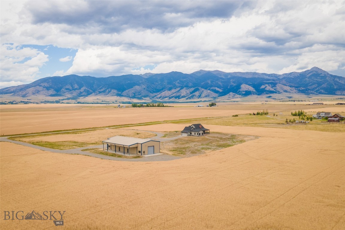 Here is an exceptional opportunity to acquire a remarkable 40-acre property in the Gallatin Valley. This idyllic setting offers breathtaking panoramic views of the Bridger Mountains with an abundance of wildlife in the area, providing a tranquil retreat while remaining conveniently located.
The single-story, custom-built home boasts three bedrooms and two and a half bathrooms, featuring an open floor plan with vaulted ceilings and exquisite hardwood floors. Natural light floods the interior, highlighting the meticulous attention to detail throughout. From the large kitchen and culinary island to the extensive primary suite, large windows provide surrounding scenic views to catch your eye at every turn. A spacious covered patio, accented with red brick, welcomes you and provides an ideal space for outdoor relaxation. The home is surrounded by a golden wheat field, and the landscaping is prepared with topsoil and ready for your personal touch.
Beyond the home lies a substantial +/- 4,600-square-foot heated shop, complete with 14-foot garage doors and additional lean-to space, perfect for storing equipment, vehicles, and recreational items. The property also features 220-amp service, full RV hookups, two 1,000-gallon propane tanks (serving both the home and shop), and a dosing tank with two installed septic systems – one septic for the existing structures and one septic for additional future home.
This property represents an unparalleled opportunity to own a piece of Montana's natural beauty, offering both comfort and practicality. I invite you to schedule a showing at your earliest convenience.