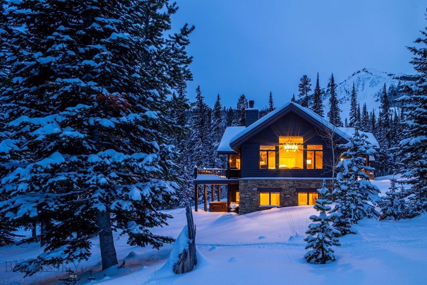 Located in the Diamond Hitch neighborhood of Moonlight Basin, this ski-in ski-out home at Big Sky Resort offers exceptional ski-out access with a groomed trail adjacent to the home leading to the Explorer Gondola and Pony lift. You can also walk a short distance to Challenger and be among the first on the upper mountain for powder turns, with ski-in return from much of Lone Peak. Set on 1.375 acres among mature pines with Spanish Peaks views, the setting feels distinctly mountain and wonderfully private. Inside, the vaulted great room features exposed timber beams, a tongue-and-groove wood ceiling, hardwood floors, oversized windows, and a stone-surround wood-burning fireplace. Numerous updates include a water filtration system and an updated kitchen designed for après and entertaining with Viking appliances, a generous center island, and a pantry, flowing into the dining area for easy hosting. The main-level primary suite includes deck access and a spacious bath. Step outside to a large deck, covered patio, and hot tub for year-round outdoor living in a true mountain setting. Sold furnished. Optional membership, upon approval, to Moonlight Basin provides access to additional amenities and services.