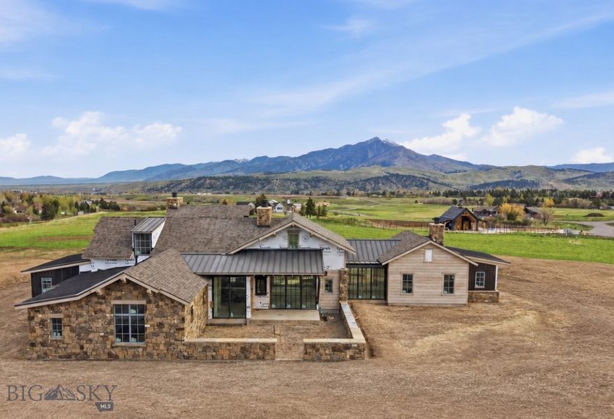This stunning new Mountain Modern home is located in Bozeman’s sought-after Sandhill Subdivision, with estimated completion in Fall '26. Current construction stage: Siding & Drywall! Situated on 2.5 acres on the desirable south side, just 3 minutes to downtown Bozeman, the thoughtfully designed home will blend refined mountain architecture with contemporary comfort—and is available for purchase prior to completion. Featuring 3 spacious bedrooms with on-suite baths, a dedicated bunk room on upper level with bath, and a seamless indoor-outdoor layout, this home is perfectly positioned to take in sweeping views of the Bridger and Gallatin Mountain ranges. The design showcases organic accents with natural stone and wood siding —capturing the timeless spirit of Montana with a fresh, modern twist. The plan also includes a custom-designed pull-through barn, 490 SF of additional finished space, including a private office with 3/4 bathroom, kitchenette, spacious flex room (can be customized), and additional garage bays, creating a flexible space for work, storage, and recreation. Inside, expect cozy open-concept living, vaulted ceilings, dramatic fireplaces, and oversized windows that frame the landscape and flood the home with natural light. Located just 5 minutes from downtown Bozeman, yet nestled in the quiet hills of the country, this is an opportunity to own a brand-new home in one of the area’s most exclusive settings. Buyers who secure the property early enough may customize select finishes. Sandhill Subdivision has a beautiful community barn for residents with a putting green, park, sled hill and green space. It also prioritizes open spaces, dedicating over 40% of the development to wildlife, riparian habitat, and native plant species, and is adjacent to an extensive trail network linked to Gallatin Valley Land Trust trails.  Experience elevated mountain living—where thoughtful design, privacy, and organic beauty come together in the heart of southwest Montana.