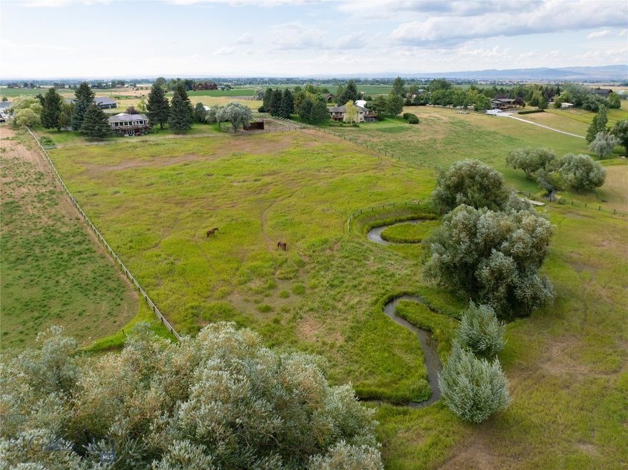 Experience the pinnacle of Montana living on this meticulously curated 4.81-acre estate with Baxter Border Tributary of Bozeman Creek meandering through it. Located just minutes from the vibrant heart of Bozeman, this property offers a rare "best of both worlds" lifestyle: the privacy and space of a premier horse property paired with the convenience of town. The home is oriented to capture the stunning peaks of the breathtaking Bridger Mountain Range. Originally built in 1978 and completely gutted and reimagined, this home has been transformed into a sophisticated modern sanctuary. The open-concept main level is defined by expansive windows that draw the eye toward the snow-capped Bridgers. The home’s sustainability is anchored by a newly installed, high-efficiency solar array. The Chef’s kitchen is a true culinary center featuring double ovens, a gas range, granite countertops, and a central island designed for entertaining with a dining area that walks out to the expansive deck.  The living room gas fireplace completes the main level.  A dedicated executive office behind elegant French doors with custom built-ins—perfect for the remote professional. The Primary Master Retreat is a tranquil main-level suite featuring dual vanities and a walk-in closet, designed for seamless morning routines.  The walk-out basement transitions into a covered patio oasis, complete with a hot tub positioned to soak in the mountain views. A spacious family room with a quaint gas stove provides a cozy retreat for Montana winters.  There are three bedrooms with egress windows and a guest bathroom with two sinks. This isn't just land; it’s a high-functioning estate. The Baxter Border Tributary winds gracefully through the acreage, providing a lush, well-maintained fenced pasture. Included is an auto-heated waterer for horses. Advanced groundworks features natural mineral fines around the upgraded loafing shed. About 4 acres of hay and alfalfa pasture. The detached shop has an approximate 12-foot door, and "flex space" for a hobby or workshop. The grounds are a private arboretum with a park-like yard. Enjoy an orchard of apple, crab apple, and choke cherry trees, complemented by 3 raised irrigated garden beds and vibrant tulip displays. The UG Sprinkler system ensures the landscape remains as breathtaking as the mountains behind it. Rarely does a property combine such meticulous "pride of ownership" with this specific set of assets, all within a few minutes' drive of Bozeman.