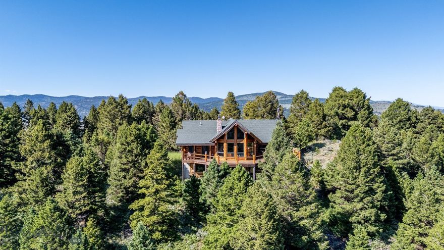 Escape to this beautiful log home on Johnny Martinez Trail, where rustic charm meets modern comfort in Bozeman's scenic foothills. Surrounded by towering pines and offering breathtaking mountain views in every direction, this property is pure Montana magic. The heart of the house is the dramatic great room with soaring timber ceilings, a stunning stone fireplace, and walls of windows that showcase those incredible views, while rich hardwood floors and warm log walls create a cozy yet sophisticated atmosphere throughout. The gourmet kitchen features beautiful wood cabinetry, granite counters, and stainless appliances – perfect for everything from morning coffee to dinner parties. The master bedroom is conveniently located on the main level, offering a peaceful retreat with log walls, forest views, and gorgeous vaulted ceilings, while upstairs you'll find a charming loft space accessible via a rustic staircase with natural wood railings that adds authentic mountain character. The basement level provides excellent additional living space with two bedrooms and a full bath, plus an unfinished area that offers endless possibilities for customization – whether you envision a home gym, media room, or whatever suits your lifestyle. The expansive deck is where this place really shines, with multiple outdoor spaces that take full advantage of the spectacular mountain views – perfect for morning coffee, evening drinks, or just soaking in Montana's natural beauty. Adding to the outdoor appeal is a private stocked pond on the property, perfect for casting a line right from your backyard or simply enjoying the peaceful water feature. Nestled on a private, wooded lot that feels like your own personal forest, you'll have complete privacy while still being convenient to Bozeman and Livingston, creating the perfect balance of mountain retreat and accessibility. This isn't just a house – it's your gateway to the Montana lifestyle, where every day feels like a vacation and every view takes your breath away.