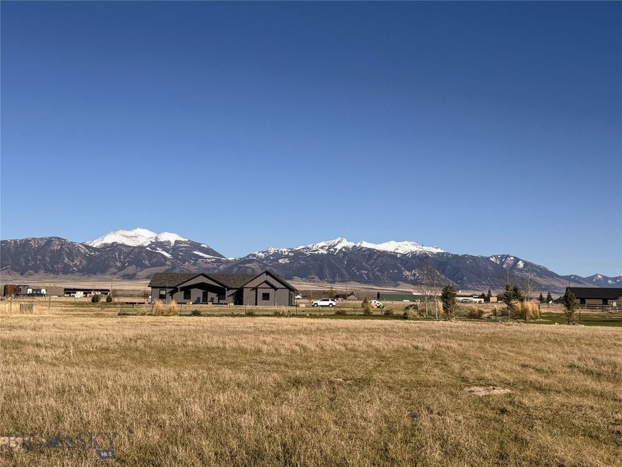 Positioned in one of Ennis’ most sought-after neighborhoods, this 1.64-acre homesite in Sky View offers an exceptional opportunity to build with both views and lifestyle in mind. Overlooking the community pond, the property captures sweeping panoramas of the Madison Range, including iconic Fan Mountain; delivering the kind of Montana backdrop that never gets old.
Thoughtfully designed for both connection and tranquility, Sky View features paved pedestrian and bike trails linking directly to the town of Ennis and the K–12 school, creating effortless access to daily amenities while preserving a quiet, residential atmosphere. Outdoor enthusiasts will appreciate direct trail access to Madison Meadows Golf Course, with the rare convenience of driving your golf cart straight to the clubhouse.
With a coffee shop and fitness facilities nearby and just minutes from downtown Ennis offering retail shopping, restaurants, the grocery store, and the hardware store, this property strikes a perfect balance between small-town accessibility and wide-open Montana living. Merely one hour from Bozeman/Yellowstone International Airport and just over an hour to Yellowstone Park.  Build your vision in a setting that offers space, scenery, and a true sense of place.