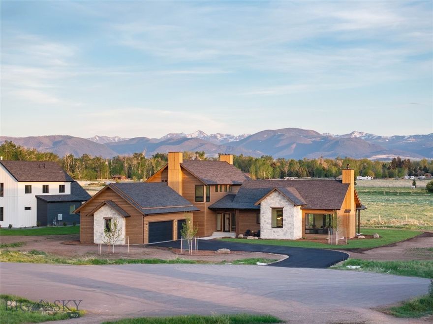 Set on a quiet cul-de-sac in the Coolwater neighborhood, this newly constructed home blends custom design with functional living, offering views of the Bridger and Hyalite Mountain ranges. Thoughtfully designed covered outdoor living spaces are positioned to enjoy balanced natural light throughout the day, while cedar siding and real stone accents complement the home’s warm mountain-modern aesthetic.
Designed for everyday living and entertaining, the layout creates a seamless connection between the kitchen, dining, and living spaces while still giving each area definition and purpose. The main living room is anchored by a custom stone fireplace and expansive windows framing the surrounding mountain views. Beam-accented vaulted ceilings and soft architectural arches add warmth, scale, and character throughout.
The kitchen features custom cabinetry, a panel-ready appliance package, under-cabinet and toe-kick lighting, and warm, refined finishes. A spacious walk-in pantry with an additional refrigerator provides exceptional storage and functionality. Integrated Sonos speaker system in the living room, primary bedroom, and primary bath.
Privately situated, the primary suite is designed as a true retreat with vaulted ceilings, wood beam accents, a statement wood accent wall, and direct access to a private covered patio. The home offers 4 bedrooms plus a dedicated office that can function as a fifth bedroom, along with 3 full bathrooms, a powder bath, and an upper-level bonus space for additional flexibility.
Situated on 2.4 acres, the property offers privacy, open meadow surroundings, and expansive mountain views while still being conveniently located near Bozeman and within the Monforton School District. The lot configuration also allows potential for an accessory dwelling unit (ADU).
Built by Triple Peak Construction