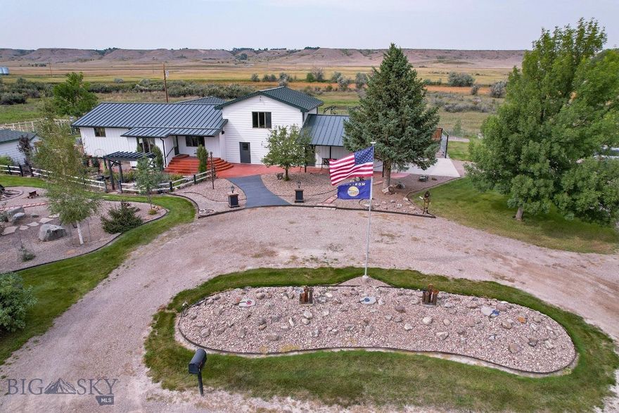 Enjoy a fine country home with 4 bedrooms and 4 bathrooms on an immaculate and park-like 1.67 acre setting with access to a slough of the Sun River that has fish! You'll love the $72K of BIG and BRIGHT new windows that take in butte, mountain and river views. As you come in the front door, you enter an open sunroom that abuts the main living space with soaring ceilings and a gas fireplace, which then leads up to an enormous recreation room. The efficient kitchen next to a long dining room with doors that lead down to a tiered patio and backyard boasting clever pavers, an outdoor fireplace, arbor, play set and more. All four bathrooms; 2 full, a 3/4 and a 1/2, and all the bedrooms have all been tastefully remodeled. From the kitchen, you can go into a work room and an adjoining garage. The roof is an upgraded, high-end metal. The property is surrounded by undeveloped ranches, so offers peace and privacy. NO COVENANTS, NO HOA, so bring any kind of critter you'd like to bring and no fees! Two sheds convey and there's a slick irrigation system for keeping your manicured grass green. Mature landscaping and trees. Attached two car garage. Well. Central air. Recently-pumped septic. Easy access to Great Falls and nearby small, rural towns.