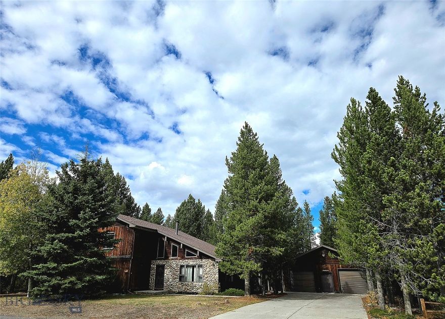 Nestled among pine trees and just minutes from Yellowstone National Park’s entrance, this welcoming 2,852 sq. ft. home offers a unique combination of comfort, privacy, and a close connection to nature. Situated on two lots in the Madison Addition, the residence is surrounded by beautiful scenery and presents a wonderful opportunity for homeownership in this highly sought-after area.
This home features four bedrooms and three full bathrooms, providing ample space for families and guests. Vaulted ceilings in the main living room create an open and airy ambiance, accentuated by warm, natural light. The layout includes a large family room, a generous living room, kitchen and dining area.
Step out from the dining room onto a private patio deck surrounded by trees—perfect for relaxing outdoors or entertaining guests. From the deck, enjoy peaceful views and take in the tranquil beauty of Yellowstone living.
This property also offers a two-car garage and a wide driveway, ensuring plenty of parking and convenience. There is a full basement that provides the potential for additional living space.
Located in a quiet and desirable neighborhood only five minutes from Yellowstone’s West entrance, this home is the perfect choice for a permanent residence or a vacation retreat in Yellowstone.
