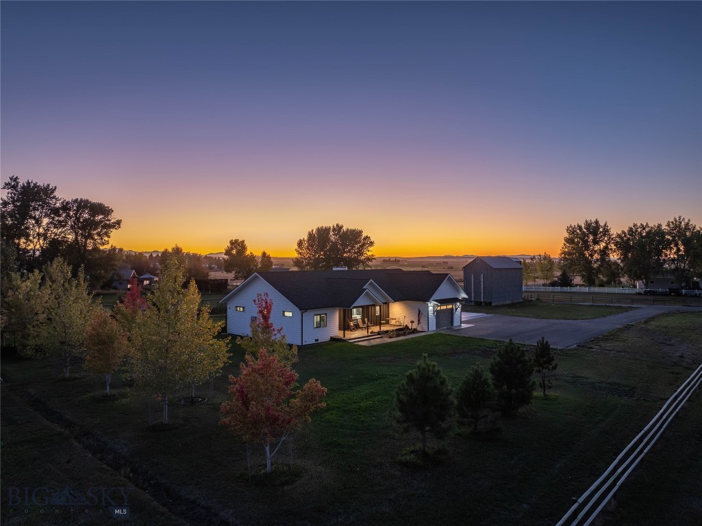 A rare opportunity for both lifestyle and income, this versatile 4.3-acre property just outside Manhattan offers the freedom of no covenants, no zoning, and approvals already in place for future commercial use. Whether you envision a home-based business, an income-producing shop, or a multi-use development, the possibilities are extraordinary. The 2019 custom ranch home blends comfort with quality, featuring 3 bedrooms, 2 baths, real hardwood floors, vaulted ceilings, a wood-burning fireplace, and an attached OVERSIZED 3-car garage with in-floor radiant heat in the garage. Additional highlights include a root cellar with a geothermal loop, a lush garden area with drip irrigation, and a historic granary that adds both charm and utility. The property is infrastructure-ready and uniquely positioned for expansion. It includes septic approval and installation for a 3-bedroom home, allowing another residence to be built, permits for an additional commercial building, and three commercial-grade stormwater vaults already in place to support future paving and development. With no covenants and no zoning, the options for residential, agricultural, or commercial ventures are wide open. Outdoor amenities further enhance the lifestyle. Custom 6-foot fencing encloses the backyard and garden oasis, supported by underground sprinklers, a dedicated garden shed, and a chicken coop with electricity for self-sufficient living. Outbuildings include an impressive commercial-grade shop with office space, ideal for contractors, entrepreneurs, or hobbyists. Paved access, sweeping mountain and valley views, and close proximity to the Gallatin River and Bozeman complete this exceptional property! One that offers both immediate livability and extraordinary long-term potential.