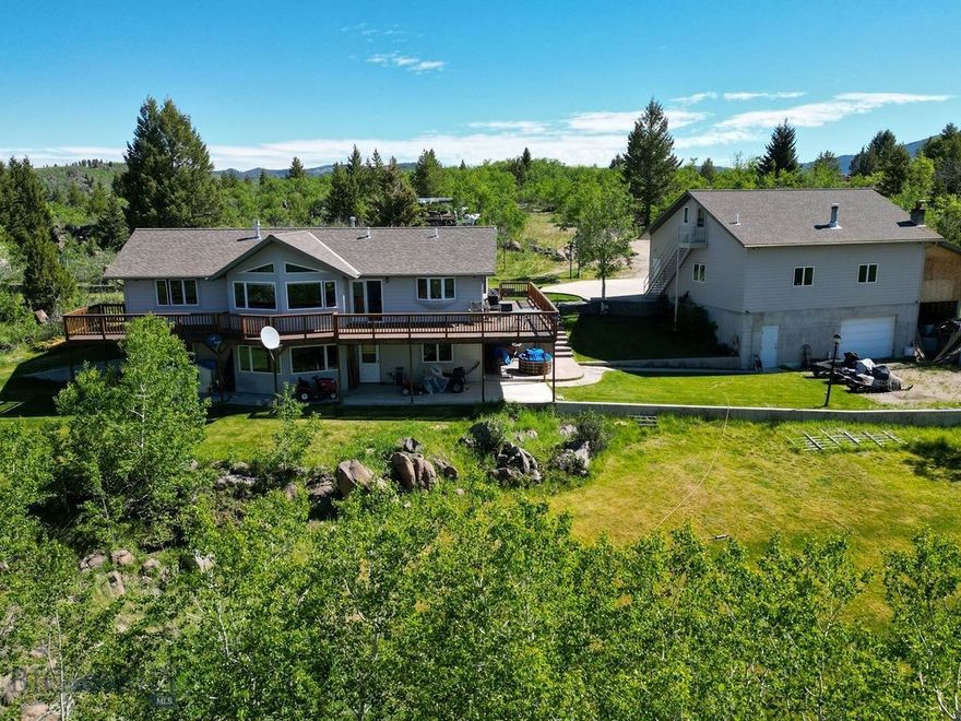 Welcome to your private Montana escape! Nestled on 16.93 acres of beautifully treed landscape, this 2,880 sq. ft. home blends space, comfort, and craftsmanship. With 4 bedrooms and 2.5 baths, the all-wood interior was custom-built by a master craftsman, creating warmth and elegance throughout.

The property is designed for both living and entertaining: enjoy stunning mountain views from the expansive deck, or gather in the basement, already plumbed for a wet bar.

A true standout feature is the 5-car garage and shop. Plumbed for in-floor heat and a bathroom, it includes a dedicated wood shop and upstairs guest quarters, also plumbed for water—ideal for visitors, extended family, or even an Airbnb. An attached storage unit provides extra room for tools and toys.

Modern comforts include an air exchange system, reverse osmosis, radon mitigation, and a full alarm system. And now with a newly paved road, access to this serene property is easier than ever.

Love playing outside? Moulton Reservoir Nordic Ski trails are just down the road; perfect for winter-time fun, or hiking in the warmer months!