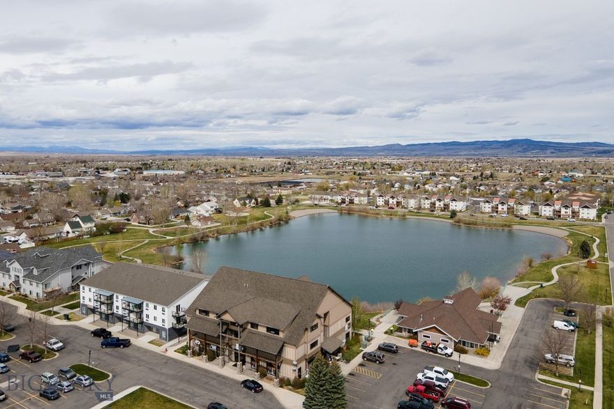 Gorgeous and Affordable! A fully-furnished turnkey luxury condo with investment/VRBO potential. Enjoy a profitable vacation rental business & second home in one! Stellar mountain views from this 3rd-floor condo in River Rock subdivision overlooking the pond w/upgraded finishes and simplicity of a move-in-ready home. Immaculate condo features an industrial feel with a spacious open concept perfect for entertaining, beautiful maple hardwood throughout, air conditioning, subway tiled shower. The building is equipped with an elevator, an indoor stairway for easy access, and is handicap accessible. It also has a convenience store, as well as a community for residents to utilize. Enjoy a sidewalk around the perimeter of the pond. Located within 1 mile of the E Gallatin River and fishing access, a short drive to skiing, and a 10-minute drive to the airport. These units have demonstrated exceptional vacation rental profits starting at around $180/night. HOA includes gas, water/sewer, and garbage.
