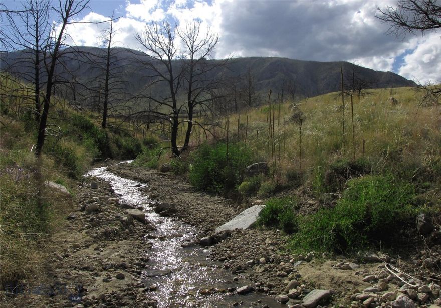 Are you looking for your own private retreat?  This beautiful property at the foot of the Beartooth Mountains borders public land and has seasonal Gold creek cutting through it. The 20 acres offers huge views of Beartooth mountains as well as views across the Clark's Fork of the Yellowstone River valley to the Pryor Mountains and even the distant Bighorns. All this with the peace and quiet found with end of the road seclusion. Are you looking for a site for your Montana cabin or a place to camp far from city lights or maybe even a place for year-round living in the mountains (some snow plowing and a 4x4 would be needed)? Miles from power, but south facing slope offers lots of sun for solar.  Some folks do live in the area year-round. This property is partially fenced and gives you direct access to BLM public land to the north, access that connects into the National Forest 2 miles to the west, well over a million acres of public land to enjoy. In fact, if you had time, you could hike all the way to Yellowstone National Park 50 miles away as the crow flies! This land is approximately 9 miles west of HWY 72; but the last 3 or 4 miles is not maintained. It is 13 miles to Belfry (pop 200), 11 miles to Red Lodge via seasonal Meeteetse Trail road (28 miles via Belfry). You would be about 70 miles southwest of Billings. Mild Covenants, but no HOA for enforcement. Property was burned in 2021 wildfire so it lost its trees. Wildlife includes elk, deer, antelope, moose, sage grouse, Hungarian partridge, coyotes & bears, even on occasion you may see a grizzly or some wolves.  Call to set-up an appointment.  The owner will finance with 20% down.