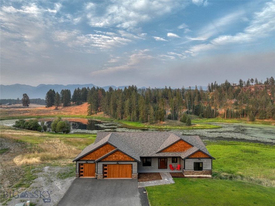 This beautiful, custom-built home is only a few minutes outside of Bigfork but offers all the quaintness of a homey remote cabin on a pond. It is an entertainer's dream! Walk through the entryway and be welcomed by an oversized view of the pond and Swan Mountain Range through (nearly floor-to-ceiling) windows. The giant living room with a gas fireplace matches the kitchen’s large cabinets and granite island. Stroll down the copper-trimmed stairs to the bar with seating for ~14 people + a full-sized refrigerator, a cozy gas fireplace, and a man-cave proportioned theater room. Guests will be begging to join you and your family here for holidays, birthday parties, and all the televised sports games. Beautiful Jewel Basin views greet the Primary Bedroom separated across the main level. Fully equipped with a royalty-sized closet (+ built-in) and attached private bathroom with double sink vanity, stunning walk-in tiled shower with bench, and single bathroom stall for seclusion. Storage space was front of mind during this build. 1,132 sq ft 3-car oversized garage, bedrooms boasting walk-in closets (with automatic lights), bathroom closets, and a large storage room downstairs fully finished. Or maybe a golf simulation room instead? This house’s upgrades come standard. The sprinkler system is set up, the theatre room is wired for surround sound, and the air conditioner keeps summer cool. Despite its large layout, the seller has raved about how energy efficient it is. Efficiency matched with quality provides a simple living. There is no better way to love Montana life! Enjoy the pond, the view, and your family and friends outside on the 640 sq ft of deck space downstairs and up. String some lights and enjoy yourselves! This home was started in 2021, finished in 2022, and is now move-in ready for its first family! Buyer to verify all information to their satisfaction.