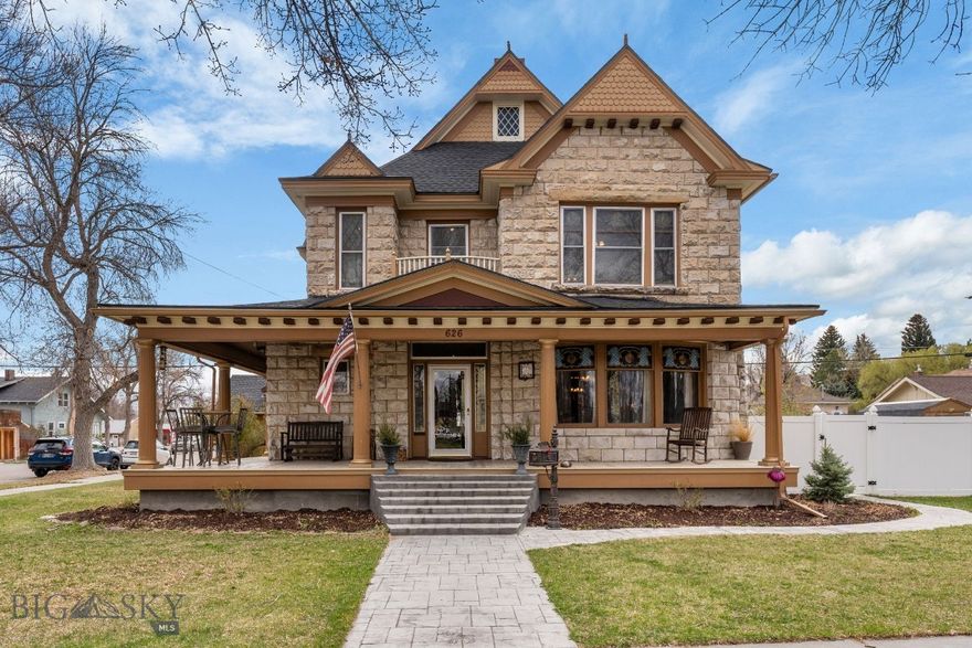 Timeless craftsmanship and architectural presence define this remarkable 1900-built stone residence, once owned by a former Lt. Governor. Prominently positioned on the corner of S. Pacific and E. Dillon Streets near the University of Montana Western, this stately home sits on 5 city lots and offers more than 4,000 sqft filled with historic character, curated detail and thoughtful updates. A separate 2 bed, 2 bath guest cabin rental provides an opportunity for supplemental income.

The exterior makes a lasting impression with stone masonry, classic columns, ornate details and curved front windows with stained glass accents, framed by an expansive wraparound front porch. A stamped concrete walkway leads to the front door where beautiful woodwork, hardwood floors and original light fixtures reflect the quality and craftsmanship of the early 1900s. The grand staircase serves as a standout focal point with detailed woodwork and vintage lighting.

The main level features a large living room, sitting room with a wood stove, library area and formal dining room. The updated kitchen includes quality cabinetry, stainless steel appliances, a gas cooktop, eat-in island and bar sink.
All 5 bedrooms are located on the upper level, one of which features an iconic widow's walk style upper-level balcony. The primary suite offers a remodeled bathroom with a tiled shower, dual sinks and marbled tile heated floors. The guest bathroom has also been updated with tile flooring, a subway tiled shower and bead-board wall treatment. The upstairs just received new carpet in April 2026.

Further significant improvements to maintain the home include foundation reinforcement, exterior stone restoration work, roof and gutter replacements in 2020 and electrical and plumbing upgrades.

The backyard includes a large concrete patio with hardwired string lighting for grilling and entertaining, vinyl fencing and a storage shed. With approximately 0.33 acres, there is room to explore adding a garage or additional structure with city approval. Drip lines have been thoughtfully added in the flower beds and along the porch to enhance the curb appeal. The 640 sqft guest house has provided steady rental income over the last several years.

With its rich history, architectural detail and extensive updates, this is a rare opportunity to carry on the legacy of one of Dillon's most iconic homes!