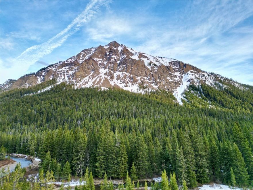 Positioned in the historic gateway community of Silver Gate, Montana, this rare 1.5-acre mountain property offers direct frontage on Soda Butte Creek just under one mile from the Northeast Entrance of Yellowstone National Park. Surrounded by the dramatic peaks of Republic Mountain and Mineral Mountain, this is a true basecamp property in one of the most wildlife-rich regions in the Lower 48.

Set within a quiet enclave of rustic log cabins, the parcel features a half-timbered and level ground with immediate creek access, ideal for fishing, relaxing, or simply taking in the alpine setting. Whether you're seeking a recreational property, mountain getaway, or investment land near Yellowstone, this location delivers unmatched proximity to outdoor adventure.

The Lamar Valley, known as America’s Serengeti, is just minutes away, offering world-class wildlife viewing with frequent sightings of bison, wolves, elk, and bears. The iconic Beartooth Highway is also nearby, providing one of the most scenic drives in the country and access to endless alpine hiking, backcountry exploration, and high-elevation lakes.

Properties this close to Yellowstone with live water, mountain views, and access are increasingly rare.

If you’ve been searching for recreational land or a legacy mountain property on the edge of Yellowstone, this Silver Gate offering captures the essence of true Mountain living.

Property Highlights
1.5 acres with Soda Butte Creek frontage
Less than 1 mile to Yellowstone National Park (Northeast Entrance)
Located in Silver Gate, MT (historic gateway town)
Surrounded by Republic Mountain & Mineral Mountain
Quiet log cabin community setting
Direct access to fishing, hiking, and outdoor recreation
Minutes to Lamar Valley (world-class wildlife viewing)
Near Beartooth Highway scenic corridor