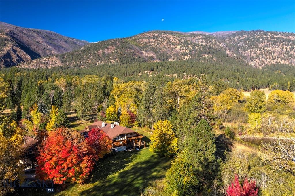 Welcome to Spring Mountain Sanctuary, ideally located in the northern reaches of Montana’s Bitterroot Valley. Minutes from the famed Bitterroot River and National Forest, this legacy property spans 84+ acres of classic pine trees, grassy forest meadows, a section of Tie Chute Creek, two ponds, and Horse Creek cascading next to a custom-built 5 bed/3 bath Montana log home. Natural light fills the home, creating an inviting space for entertaining and family gatherings. Valuable water rights support a lush landscape and a private, serene environment where outdoor Montana living thrives.
Just 20 miles to Missoula and minutes from the Bitterroot River and National Forest, the property offers convenient access to recreation while maintaining exceptional privacy.
Tie Chute Creek runs for nearly half a mile across the property, which also features two spring-fed ponds, two irrigation ditches, grassy pastures for horses or cattle, and a diverse mix of pine and deciduous trees, including Maples and Oaks that offer brilliant fall color. Horse Creek flows right near the home, enhancing the natural setting. The landscape blends mature timber and open meadows, creating both seclusion and expansive Bitterroot Mountain views. Large-acre neighboring parcels add to the peaceful rural setting.
At the heart of the property is a two-story, 6,800 sq ft custom-built, hand-peeled log home with 5 bedrooms and 3 bathrooms. Natural light flows throughout, creating a warm space for entertaining and gatherings. Also included are two offices, a craft room, living room stone fireplaces, cathedral ceilings, and multiple decks. Water rights support sustainable land use.
The property includes several outbuildings: a 1,700 sq ft 3-car garage and woodworking shop with a two-bedroom, one-bath apartment above; a well house for lawn equipment, boats, and gear; and a separate tractor/equipment shed. The land is perimeter and cross-fenced with jack-leg and barbed wire fencing, ideal for horses or a small cattle operation. County-maintained paved roads lead to the gravel driveway, ensuring reliable year-round access. The property spans four 20+ acre legal parcels.
Spring Mountain Sanctuary offers a rare combination of privacy, natural beauty, and usable infrastructure in a prime Bitterroot Valley location.