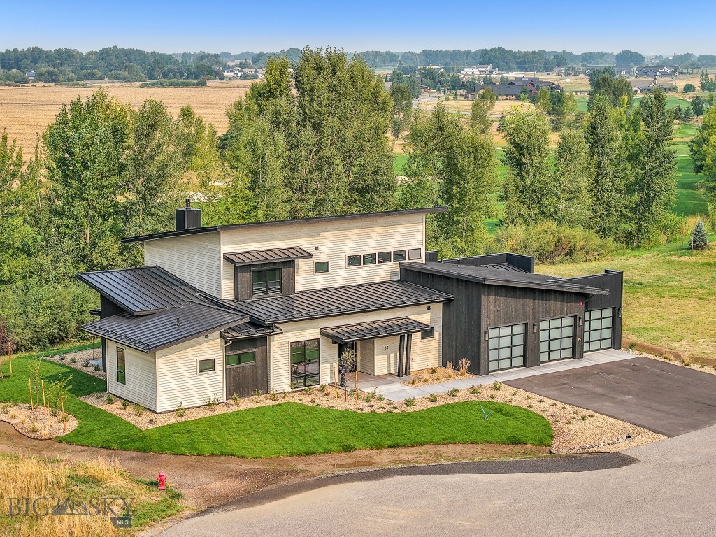 Welcome to this stunning, newly constructed two-story home located in the prestigious Black Bull community, backing up to the serene golf course. This property is a true masterpiece, blending modern luxury with thoughtful design. As you enter, you’ll be immediately captivated by the exquisite details, including beautiful hardwood floors, custom beams, built-in shelving, and a sleek custom fireplace. These elements come together to create a warm and inviting living area that effortlessly flows into the heart of the home—an impeccable kitchen that’s a chef’s and entertainer's dream. Equipped with top-of-the-line stainless steel Thermador appliances, expansive cabinetry, and a spacious pantry, this kitchen offers both style and practicality. The island serves as a statement piece, showcasing a stunning granite countertop, bar seating, and additional cabinets for extra storage. Natural light floods the home through Anderson 400 series windows, enhancing the open, airy feel of each room and offering breathtaking views of the surrounding landscape from one of the most coveted lots in the private community. On the main floor, the luxurious master suite provides ultimate comfort with private patio access and a designated hot tub location, perfect for relaxation. The spa-like master bath features heated floors, a stunning tile shower, a standalone soaking tub, and dual vanities for added convenience. The large walk-in closet includes built-in shelving, providing generous space for all your wardrobe needs. Also on the main level, you’ll find a guest bedroom, a stylish half bath, and a laundry room complete with a utility sink, and an incredible entry closet with additional drop zone opportunities for every weather condition Montana throws at you. Upstairs, provides flexible space for entertainment. The master bedrooms, with their own luxurious full bathrooms, offer the same high-end finishes as the rest of the home, including custom cabinetry and beautiful countertops. Step outside to the deck off the second-floor living area, where you’ll enjoy panoramic views of meadows, farmland, golf course, and a peaceful stream—an ideal setting for relaxation or outdoor gatherings. This home also offers separate heating and cooling zones for each level, with ceiling fans in every room for added comfort. The attached 3-car garage is heated, includes a convenient drain, and offers ample space for storage and organization. (PHOTOS VIRTUALLY STAGED)