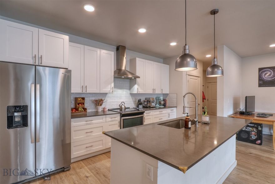 Ideally located in Livingston’s sought-after south side, The Flats at Yellowstone Bend offer a thoughtfully designed approach to modern in-fill living—just minutes from downtown, the Yellowstone River, walking trails, and convenient access to the I-90 corridor. Residents also enjoy access to a community clubhouse featuring meeting and event space along with a fitness gym, adding both convenience and lifestyle appeal. Unit 139 is a bright and spacious third-floor southwest corner residence featuring 2 bedrooms and 2 bathrooms. The open-concept living, dining, and kitchen area is filled with natural southern light, creating a warm and inviting atmosphere. The kitchen is both stylish and functional, complete with quartz countertops, shaker-style cabinetry, Whirlpool stainless steel appliances, and a dedicated pantry for added storage. Well-appointed finishes continue throughout with brushed nickel fixtures and durable laminate plank flooring. The primary suite offers a walk-in closet, and the overall layout provides comfort and livability in a low-maintenance setting. Step out onto the covered patio to take in mountain views and enjoy a peaceful outdoor retreat—an ideal extension of the living space for morning coffee or evening unwinding. Additional highlights include designated garage space (#49) and a private storage locker, perfect for seasonal gear and extra belongings. A great opportunity to own a modern, light-filled condo in one of Livingston’s most desirable locations.