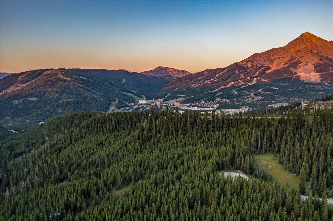An extraordinary opportunity awaits in Big Sky, Montana: over 7 acres of pristine land showcasing sweeping mountain and valley views, a gently sloped terrain, and the rare privilege of bordering 360 acres of protected conservation land. This striking property offers unmatched privacy at the end of a quiet dead-end road, while still placing you within minutes of Big Sky’s world-class amenities. The neighboring conservation parcel provides unrivaled wildlife viewing and seamless access to low-impact recreation, including direct connections to Forest Service trails that lead deep into Montana’s backcountry.
Adding to its uniqueness, the northeast corner of the property touches a serene tributary commonly known as Beehive Creek, infusing the land with the calming presence of water. From here, you are also within walking distance of the coveted Beehive Basin Trail, one of Big Sky’s most celebrated hikes, offering dramatic alpine scenery and year-round adventure. The setting strikes an exceptional balance of untouched natural beauty and accessibility to Montana’s most sought-after experiences.
The location is simply extraordinary: just 10 minutes to the world-class skiing at Big Sky Resort, 15 minutes to luxury services and fine dining at the first stateside One&Only Resort, 15 minutes to Big Sky Town Center, and 30 minutes to the Montage Big Sky. Beyond Big Sky, you are a scenic hour’s drive to the wonders of Yellowstone National Park, the Yellowstone International Airport, and the historic charm of downtown Bozeman. Here, you’ll experience the rare combination of true mountain seclusion with effortless access to world-class amenities, dining, and cultural experiences.
The property’s flexible land-use opportunities further enhance its appeal. With over 7 acres, multiple structures can be built, allowing you to design an estate that fits your vision—whether that includes a guest house, barn, detached garage, or other spaces to complement your Montana lifestyle. Horses are permitted, opening the door to equestrian living against a backdrop of awe-inspiring mountain vistas.
This is more than a homesite—it is a sanctuary where conservation, privacy, and convenience converge. Whether you’re envisioning a family retreat, a legacy property, or an investment in one of Montana’s most coveted regions, this acreage captures the very essence of Big Sky living.