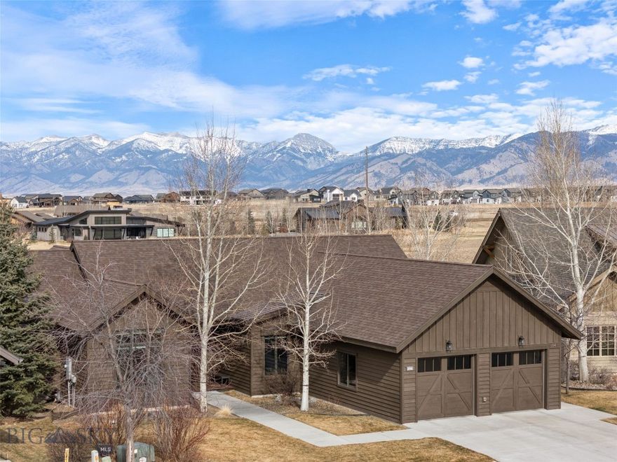 Welcome to 194 Wickwire Way! Positioned along holes 16 & 17 of the Black Bull Golf Course, this exceptional Locati-built home showcases sweeping Bridger Mountain views through floor-to-ceiling glass sliders and windows throughout the home. The large covered back deck provides the perfect vantage point to take in the mountains and fairway setting year-round. Designed for effortless single-level living, the desirable floorplan features three spacious bedrooms, each with its own private en suite bath and generous closet space, plus a powder room for guests. The living room is anchored by a striking stone gas fireplace and enhanced by warm wood beam accents, blending refined craftsmanship with Montana character. Recently refreshed with new interior paint, carpet, updated kitchen counters, and exterior stain, the home is move-in ready. An oversized two-car garage offers ample storage, while mature landscaping and a quiet street setting provide privacy—all within walking distance to Black Bull’s premier club amenities: championship golf course, private restaurant (Bar 72), pool, fitness center w steam room, and cross country ski trails. The perfect setting for easy Montana living. Some photos are club amenities.