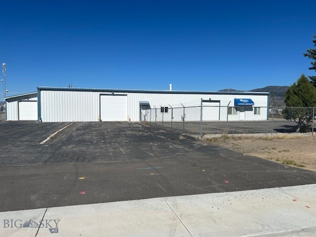 This commercial property offers a unique and versatile space perfect for a variety of businesses. The total area of 4,945 square feet is thoughtfully divided to maximize efficiency and functionality, including a dedicated 1,000-square-foot office area with a reception area, three private offices, and a restroom, which provides a professional environment for administration and client meetings. The remaining 3,945-square-foot shop is designed for high-performance operations, featuring both overhead and in-floor heating, and includes a dedicated wash bay for added convenience and utility. The fenced yard offers security and great space for outdoor storage. This makes it an ideal space for a wide range of industrial or service-oriented businesses.
