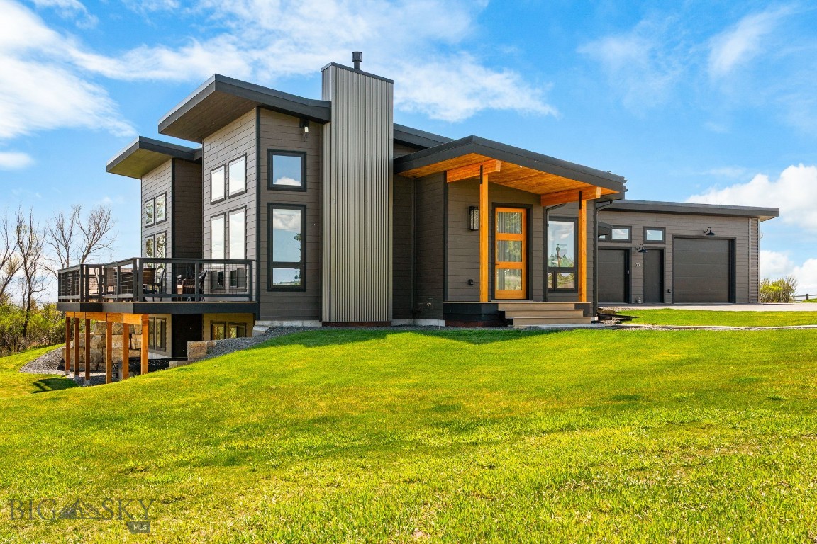 Welcome to 20 Prairie Falcon Lane – A Modern Retreat with Breathtaking Views, in a semi-rural setting yet just 10 minutes from Bozeman Yellowstone International Airport, and 20 minutes from all the conveniences Bozeman has to offer.
Perched on over 2 acres atop a ridge, this stunning contemporary home offers commanding panoramic views of the Gallatin Valley and Bridger Mountains. Designed with warmth and elegance, this nearly new residence combines modern sophistication with practical comfort, exceptional craftsmanship, and thoughtful details throughout.
The main floor features seamless single-level living, where the open-concept great room, kitchen, and dining areas are framed by vaulted ceilings, expansive windows, and a striking fireplace—perfect for entertaining or quiet evenings at home. Step into the chef’s kitchen, complete with custom bamboo cabinetry, honed Larvikite granite countertops, prep sink, coffee bar, butler’s pantry, and high-end Thermador appliances.
The luxurious primary suite captures awe-inspiring mountain views through oversized windows, and includes a spa-inspired bath with dual sinks, a generous walk-in tiled shower with dual heads and handheld, and a spacious walk-in closet.
The walkout lower level expands the living space with three large bedrooms, a full bath, office, and a secondary living area—ideal for guests or multi-generational living. Radiant in-floor heating spans both levels, complemented by mini-split units for year-round comfort.
Outdoor living is just as impressive. Enjoy sunsets from the expansive main-level deck, or soak under the stars in the hot tub on the covered lower patio while the moon rises over the Bridgers.
A massive 1,200+ sq ft heated garage/shop includes two separate bays—one with a kitchenette and ¾ bath, offering incredible flexibility for hobbies, workspaces, or guest quarters. Plus, the property allows for a future 1-bedroom ADU.
Turnkey homes of this quality, space, and setting are a rare find. Schedule your private tour today and experience Montana living at its finest.