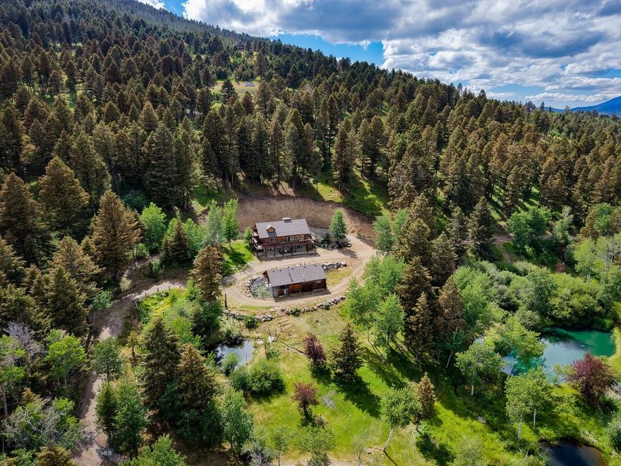 Discover a rare and exceptional opportunity with this one-of-a-kind 40+ acre horse property (divided into two lots), perfectly equipped for both serious equestrian use and year-round living and recreation. Featuring a charming 4-bedroom, 4-bath (one full, two 3/4, & one 1/2) 3 level log cabin. The cabin has a lower level entrance that could be used as a mother-in-law suite and approximately 2464 sq/feet of living space with a prominent wood fireplace as the centerpiece of the living/kitchen area. The property features 4 outbuilding for various uses including horse/livestock stalls, shop, greenhouse, chicken coop, and amazing storage for your toys. The property is designed for functionality and comfort. Irrigated landscaping (including 27 sprinkler zones which shows just how much water this property can utilize), water rights, and several scenic ponds add beauty and value—water is one of the West’s most precious resources and this property has it in spades.

Conveniently located just over an hour from both Helena and Bozeman, and under 30 minutes to White Sulphur Springs and Townsend, you're never far from modern amenities while enjoying the peace and privacy of rural Montana living. Common sense covenants help preserve the character and value of the area, which is well-known and sought after. This is a true four-season recreational haven. Ride or hike in the area's vast public lands, explore extensive snowmobile and ATV trails, fish nearby rivers and lakes, or ski at Showdown Ski Area—less than an hour away. After a day outdoors, unwind at the historic hot springs and enjoy a local brew in the lively town of White Sulphur Springs.

The Details Include: Appx 2464 Sq/Foot Home on two lots that each are just over 20 acres (40.2 +/- total); Outbuildings include (starting closest to home and working further away) (1) 31x25 ft enclosed with stalls, alleyway, and two rooms, and upstairs storage & 25x13 ft overhang; (2) 54x42 ft with 3 stalls, alleyway and storage room with attached 36x15 ft workshop and 24x15 ft and 54x15 overhangs (covered storage); (3) 96x30 ft equipment barn with 30x16 ft overhang (covered storage); and a (4) 36x36 ft commodities barn with 28x15 ft overhang (covered storage). There are also two wells, 6 water rights, 5 ponds (two with fish permits), 5 owned propane tanks, a backup generator, and a small greenhouse for those gardeners out there.