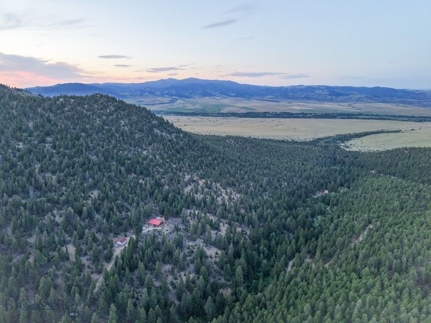 This 29+/- acre property located in Jefferson County, Montana offers a rare combination of privacy, access, and recreational opportunity. Tucked within the timbered mountains, the parcel includes a two-bedroom, one-bathroom cabin powered by solar with battery storage and a generator backup. The open-concept living and kitchen area creates an efficient and functional space for off-grid living or seasonal recreation. Propane and wood heat provide multiple options for climate control. A non-permitted grey water septic system with on-demand hot water services the cabin, and an outhouse is included for additional nature calls. Currently the owner transfers water to the property via a portable tank, and there is not a well on-site.
Year-round Quinn Creek flows through the property, providing a reliable water feature and attracting wildlife to the area. The property is elevated above the valley floor, offering expansive views and a secluded feel.  The greenhouse features a gravity-fed water system to support small-scale gardening efforts. For equipment and vehicle storage, the property includes well built garage. Access is via a private easement road that crosses a large neighboring ranch, adding a significant layer of privacy and security for the owner. A major highlight of this property is the ownership's connection to an adjacent square mile of U.S. Forest Service land and another square mile of State Trust land. These public lands are effectively landlocked and inaccessible to the general public, making them available primarily to landowners in this area. This unique feature enhances the property's recreational potential for hunting, hiking, and wildlife viewing. Located in a general hunting area with frequent sightings of deer and elk, the property offers strong potential for hunters and wildlife enthusiasts. The proximity of timber, water, and terrain provides attractive habitat for big game species.
This property is a strong candidate for a recreational retreat, hunting basecamp, or an off-grid residence, with significant value stemming from the private access to otherwise difficult-to-reach public lands. It is within reasonable driving distance of nearby Montana communities including Boulder, Whitehall, and Helena, offering convenience without sacrificing seclusion.