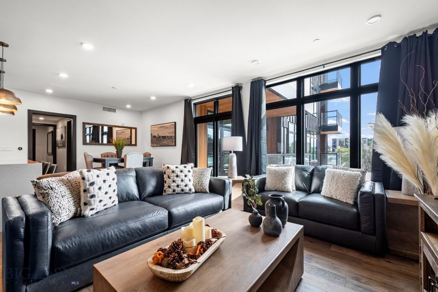 Welcome to Unit #306 at The Henry, a premier six-story condominium community in the heart of Downtown Bozeman. This untouched, fully furnished residence offers true turn-key living, combining modern style with the convenience of a central location. The sleek kitchen and dining area open to a covered balcony with views of downtown, perfect for morning coffee or evening relaxation. Natural light fills the generously sized living room, creating a bright and inviting space for gathering or unwinding. Just off the living room, you’ll find the guest bedroom—ideal for visitors or a flexible office setup. The master suite is privately situated near the entryway and features a walk-in closet and ensuite bathroom, offering both comfort and functionality. At The Henry, lifestyle extends beyond your front door. Residents enjoy a fitness center on the ground floor, a private landscaped courtyard, and secure climate-controlled underground parking. Just three blocks from Main Street, you’ll have Bozeman’s renowned restaurants, boutiques, and cultural venues within easy reach. For outdoor adventure, Bridger Bowl is 25 minutes away, and Big Sky Resort less than an hour’s drive—perfectly blending city convenience with Montana’s world-class recreation.