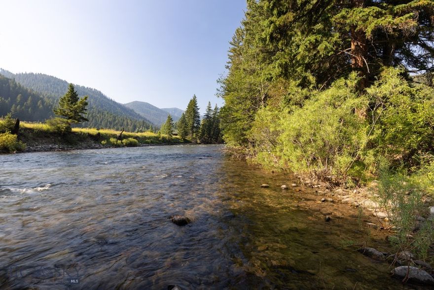This exceptional 1.1-acre property offers coveted Gallatin River frontage, without the drawbacks of Highway 191 exposure. Experience the perfect combination of privacy, functionality, and luxury in a stunning, highly sought-after riverfront setting. You'll enjoy expansive mountain views and direct access to all types of river recreation, including premier blue-ribbon fishing. Just steps away from the property is access to the National Forest Service trailhead. The prime portion of the property nearest the river is an open canvas for your dream home, with infrastructure in place to build. The property currently has an oversized two-car garage with floor drains connecting to a fully equipped shop featuring both 110 and 220 power and radiant floor heat, ideal for any scale of work or hobbies. Above the garage is a private, separately metered 1-bed, 1-bath apartment with radiant floor heating—perfect for guests. Convenient access to all the amenities of both Big Sky and Bozeman. Additional features include a large storage shed and peace of mind knowing the property is outside the floodplain. This property is a rare opportunity to own a highly versatile, scenic piece of Montana’s riverfront paradise.
