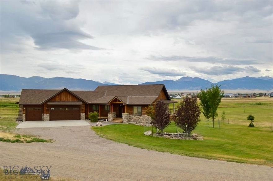 Set on 2.8 acres and bordering a 31-acre common area, this 4-bedroom, 3-bath custom home captures sweeping Madison Range views just minutes from downtown Ennis and the Madison River.  Designed with timeless architectural elements, the main living space features soaring vaulted ceilings, exposed beams, and a dramatic wall of windows that flood the home with natural light while framing Montana’s iconic Madison Range. The open-concept design flows seamlessly to outdoor living spaces, ideal for both entertaining and quiet evenings under big sky sunsets. The chef’s kitchen showcases alder cabinetry, acacia wood floors, concrete countertops, and slate accents, anchored by a striking stone fireplace that brings warmth and presence to the living area. The primary suite is a refined retreat with patio access and a spa-inspired bath featuring natural stone finishes and a soaking tub. The walkout lower level is designed for gathering, complete with radiant-heated stained concrete floors and a custom Montana white bark pine bar — a distinctive centerpiece crafted for memorable evenings. A rare opportunity to own a thoughtfully designed residence where luxury meets landscape and convenience.