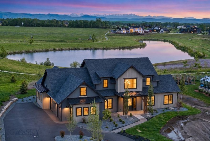 Welcome to this extraordinary residence in Bozeman’s coveted Home 40, where luxury meets Montana’s breathtaking natural beauty. Set within one of the area’s most sought-after communities, known for its private ponds, outdoor pool, clubhouse, fitness center, and more than three miles of trails, all just minutes from Hyalite Canyon and downtown Bozeman, this home offers an unmatched lifestyle. A covered front entry welcomes you into a stunning foyer, where a sweeping staircase creates an unforgettable first impression. Just off the entry, an elegant dining space is highlighted by a designer accent wall. The heart of the home is the breathtaking chef’s kitchen, thoughtfully designed with a grand center island, expansive prep space, Thermador appliance package, custom statement range hood, oversized windows, and a sink perfectly positioned to capture serene pond views. The adjoining great room is equally impressive, featuring beautiful ceiling beams, a striking fireplace, and a charming window seat, all framed by incredible natural light. A four-panel sliding glass door opens seamlessly to the covered patio, where mountain views and the shimmering pond create a stunning backdrop for indoor-outdoor living. Tucked just off the great room are two spacious guest bedrooms and a beautifully appointed full bath. On the opposite side of the kitchen, a generous walk-in pantry provides exceptional storage, while the elegant powder bath is enhanced by motion-activated ambient cabinet lighting beneath the vanity, offering both sophistication and convenience. Privately situated in its own wing, the primary suite features peaceful views and a spa-inspired ensuite with a freestanding soaking tub, walk-in tile shower with bench seating, multiple showerheads, and a beautifully designed walk-in closet. The hallway leads to a thoughtfully designed everyday living zone with a mudroom complete with bench seating, hooks, and built-in storage. Just beyond, the spacious laundry room offers abundant cabinetry, generous workspace, and a utility sink. The attached heated three-car garage adds both comfort and functionality year-round. Upstairs, you’ll find two additional bedrooms, each with walk-in closets and private ensuite baths, plus a large flex space. Set on one of Home 40’s premier homesites with pond frontage, mountain views, and access to neighborhood amenities, this custom home is the perfect blend of timeless elegance, thoughtful design, and Montana luxury living.