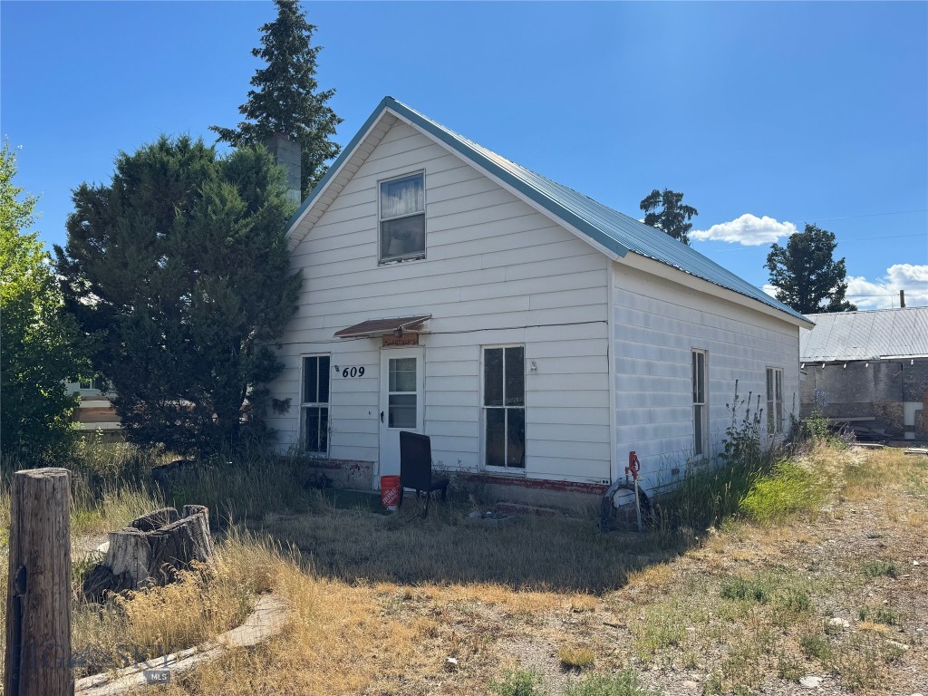 Bring your vision! Sitting on 6 city lots totaling .826+/- acres, in the quiet rural town of Lima, this property offers plenty of potential for the right buyer. The main house sustained fire damage and will require extensive renovation or removal—making this a true fixer-upper or tear-down opportunity. Also included are several outbuildings, a garage and a small 1973 manufactured home. Neither the house or manufactured home are on permanent foundations. The house and garage sit on 2 lots and the manufactured home and other outbuildings sit on 4 lots. With ample space, small-town charm, and room to create something new, this property is well-suited for investors, builders, or anyone looking for a project. Enjoy small-town living with wide open skies and mountain views. Property is being sold “As-Is”.