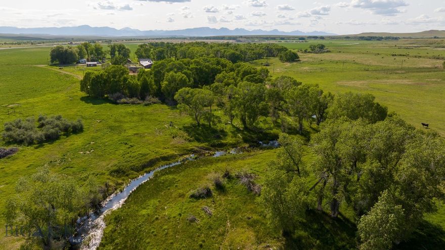 Breathtaking views of the Rocky Mountain Front and Glacier National Park provide a stunning backdrop to this exceptional 2,541-acre ranch located just four miles northwest of the charming farm town of Choteau in north central Montana. This well-maintained property seamlessly blends agricultural productivity with recreational opportunities, featuring a comfortable home and a complete set of barns, shops, and outbuildings that support both ranching operations and country living.  The ranch showcases remarkable diversity across its landscape, encompassing irrigated cropland served by 633 acres of irrigation systems, including pivot and wheel-line equipment, sub-irrigated meadows, native grassland, and lush wetlands. Riparian creek bottoms follow Baker Spring Creek.  Springs throughout the area create exceptional habitat for game birds, waterfowl, and whitetail deer.  This property presents an outstanding opportunity for agricultural operations, recreational pursuits, or conservation-minded ownership in one of Montana’s most scenic agricultural regions.