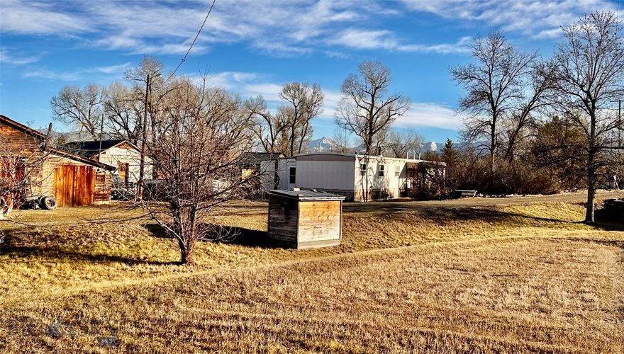 Scenic, rural farmstead on .93 Acres with no covenants and no known zoning. Endless opportunity at this high visibility location with Amsterdam Road frontage. Well-kept 4 bedroom, 2 bath 1983 Gallatin Chateau mobile home with covered porch overlooking mature landscaping and fenced back yard. (Home not on a permanent foundation) Addition includes mudroom entry and additional bedroom. Permitted 3 bedroom septic system and 60 GPM domestic well. Multiple historic outbuildings. Property being sold as-is. Located across the road from wooded Montana DNRC State section recreational use area on Baker Creek. Erwin Bridge Gallatin River Fishing Access site is close by. Located conveniently between Manhattan and Belgrade. Lot measures 145' X 280'