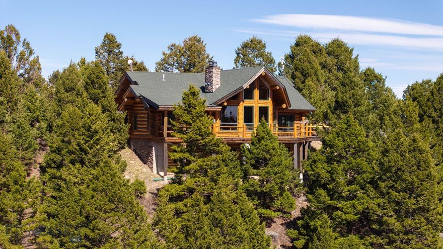 Come home to your Montana Dream log home on over 21 acres in the mountains, where rustic charm meets custom comfort only minutes from Historic Downtown Bozeman. Surrounded by native pines and offering breathtaking mountain views in every direction, this acreage is the epitome of  Montana mountain living. The heart of the home centers around the dramatic log framed great room with soaring timber ceilings, a floor to ceiling stacked  stone fireplace, and walls of windows that frame the majestic mountain vistas.  Warm hardwood floors and custom log accents create a cozy and inviting atmosphere, while the large windows allow the light  to fill every room and invites the outdoors in! The gourmet kitchen focus your attention out the windows to the secluded timber views and features wood cabinetry, granite countertops, and stainless appliances – perfect for everything from morning sunlit coffee, to light filled lunches, and intimate dinner parties. The primary bedroom suite is conveniently located on the main level, offering a peaceful retreat with log walls, forest views, and gorgeous vaulted ceilings. Upstairs you'll find a charming loft space accessible via a rustic log staircase with natural wood that adds to the authentic mountain character. The basement level provides excellent additional living space with two finished bedrooms and a full bath, plus an unfinished bedroom/office and open living area that offers endless possibilities for future customization . The expansive wraparound deck is where this place really comes to life, with multiple outdoor spaces that take full advantage of the spectacular mountain views.  Adding to the outdoor appeal is a private stocked trout pond on this secluded property, perfect for enjoying this peaceful outdoor mountain environment. All of this is nestled into a private end of the road wooded lot that feels like your own personal forest retreat.  You'll have complete privacy while still being convenient to Bozeman, Livingston, and surrounding recreation, creating the perfect balance of mountain retreat and easy accessibility. This isn't just a home,  it's your own personal slice of the famous "Big Sky" lifestyle, where days feels like vacations and the views continually take your breath away.