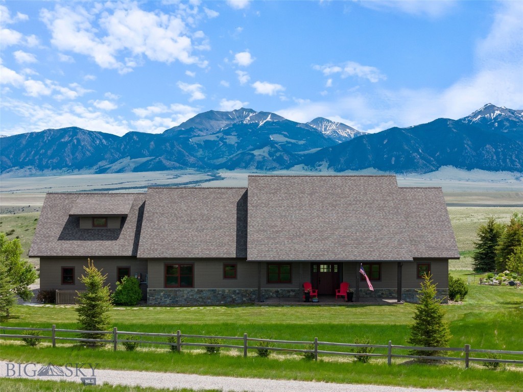 Welcome to a one-of-a-kind custom home on 7.260 acres in the coveted Pronghorn Meadows community, where luxury meets functionality and the views of the Madison Range stretch for miles. This thoughtfully designed 4-bedroom, 3-bath home offers 2,441 sq ft of refined living space — 3 bedrooms and 2 bath on the main level, with an additional private bonus room/bedroom above the garage complete with its own full bath and walk-in closet. Vaulted ceilings and engineered hickory floors welcome you into the main living area, while rich knotty alder trim, doors, and cabinetry carry throughout the home. The chef’s kitchen features a walk-in pantry, granite counters, and a 5-burner gas stove (including one long burner) — perfect for hosting or daily living.
The primary suite includes French doors to the back patio, two walk-in closets, a double vanity, a walk-in custom tiled shower, and heated tile flooring. Two guest bedrooms with large walk-in closets and a full guest bathroom offer plenty of space for family or visitors. Great storage throughout and a whole-house water softener, and solar panels for energy efficiency add exceptional value. Outside, enjoy beautifully landscaped grounds with two ponds and a waterfall, rock garden, raised beds, and a greenhouse. The stamped concrete patios are ideal for soaking in the peaceful setting. The attached 2-car heated garage is complemented by a third small bay with utility sink and additional storage. A 38x40 toy barn features a 14’ door and two 10’ doors for all your recreational needs. Two RV hookups complete this incredible property. Located just minutes from Ennis, the Madison River, and all that the Madison Valley has to offer, this home perfectly blends elegance, practicality, and breathtaking scenery.
